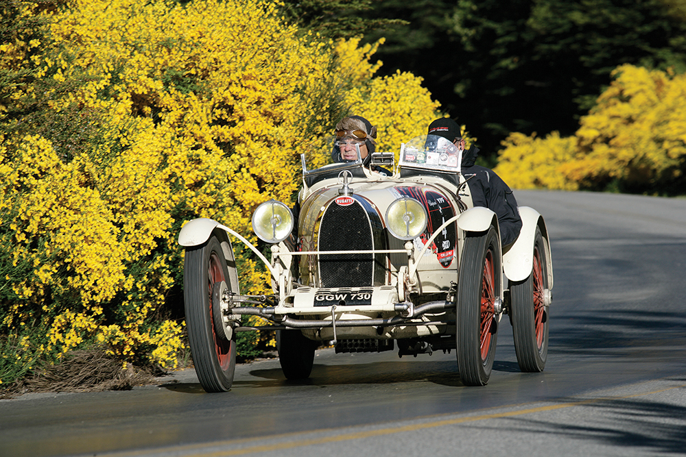 Un Bugatti de los años '20 pasea su inigualable estampa entre las coloridas retamas patagónicas.